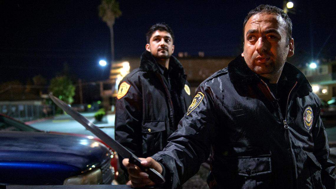 Faisal Razmal, right, holds a knife confiscated while on security rounds of three complexes including Skyview VIlla Apartments with Alal Ghupam-Ali, left. Razmal and his Afghan friend, who also has Special Immigrant Visa status, worked together on the night shift because they thought it was too dangerous to work alone. The apartment complex has since canceled that security contract. Razmal has tried washing dishes and cars and worked as a gas station janitor.