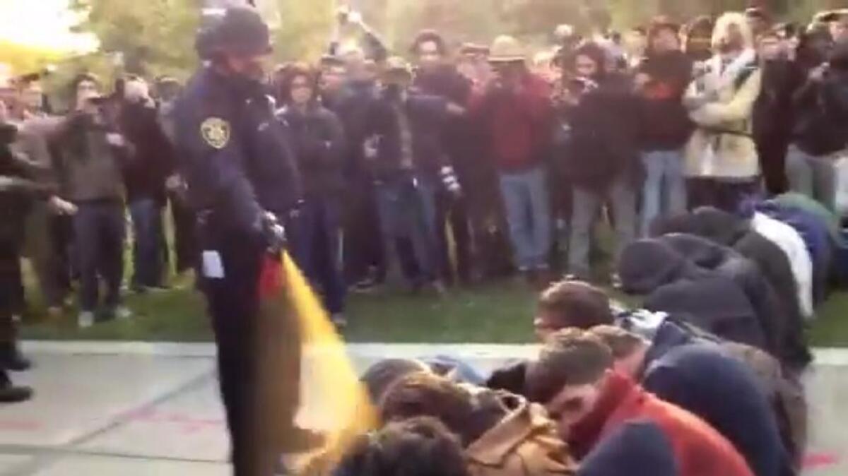 In this image made from video, a police officer uses pepper spray as he walks down a line of Occupy demonstrators sitting on the ground at the University of California, Davis on Friday, Nov. 18, 2011. The video - posted on YouTube - was shot Friday as police moved in on more than a dozen tents erected on campus and arrested 10 people, nine of them students.