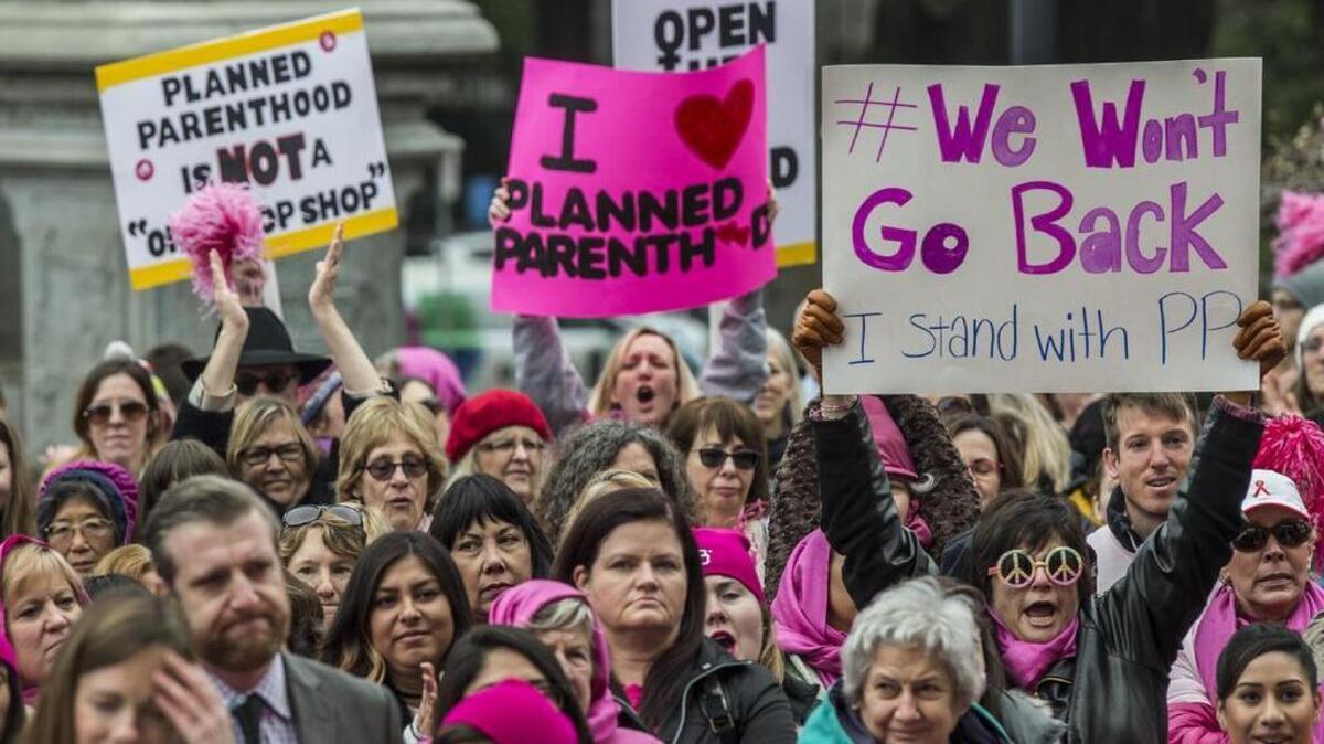 Geralyn Busnardo, far right, of San Francisco, holding sign "We Won't Go Back," attends a Planned Parenthood rally "Pink Out Day" at the state Capitol on Tuesday, Jan. 17, 2016 in Sacramento, Calif.