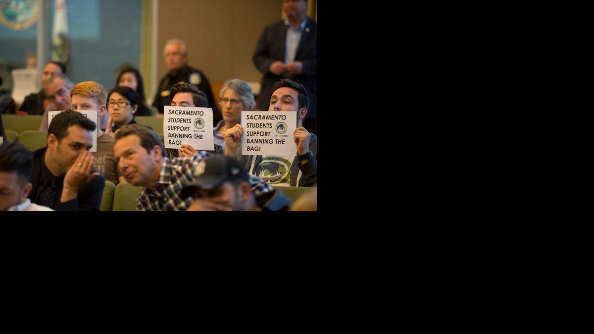 
Consumes River College students, from left, Daniel Loudon, Cesar Aguirre and Jamie Gonzalez hold up signs in support of banning plastic bags  Tuesday, at the Sacramento City Council meeting.
