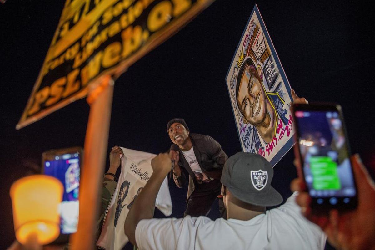 Stevante Clark, the brother of Stephon Clark hangs out the window of an SUV at the intersection of Florin and 29th Street during a vigil for his brother in Sacramento, on Fri., March 23, 2018.