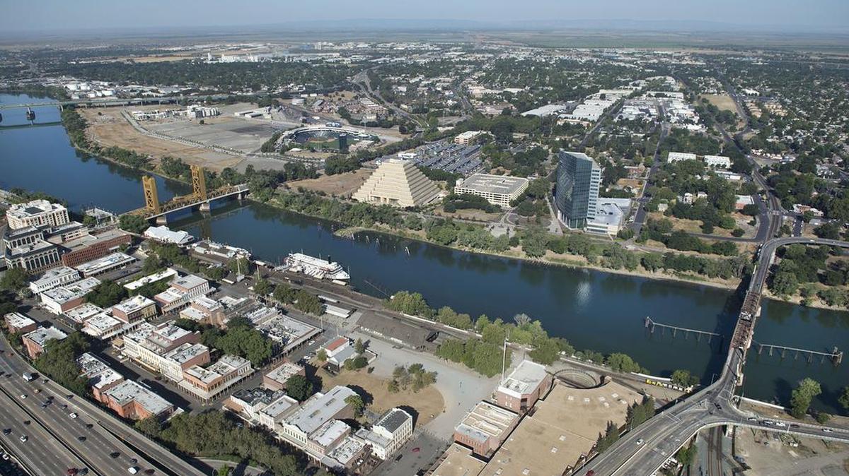 A new hotel proposal is being considered for a large grass-covered lot in the Old Sacramento historic district of Sacramento, California. The lot, pictured in the center of this aerial photograph, borders the state Railroad Museum, J Street and Front Street.