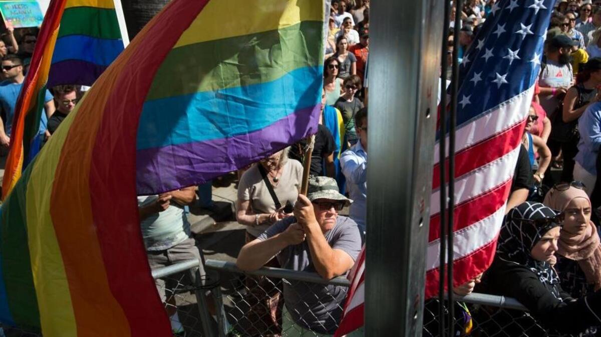 Jennifer Garland, left, holding the rainbow flag, shows support outside Faces nightclub during a vigil for the victims of the Orlando, Florida, shooting on Sunday June 12, 2016 in Sacramento, Calif.
