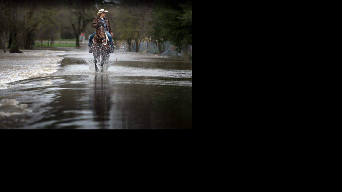 
Armando Gonzalez of Rio Linda rides his quarter horse Gitano on a flooded bike trail near Roy E. Hayer Park in Rio Linda on Friday. “I’ve seen it worse than this. It looked like a lake and you couldn’t see the grass,” Gonzalez said in Spanish.
