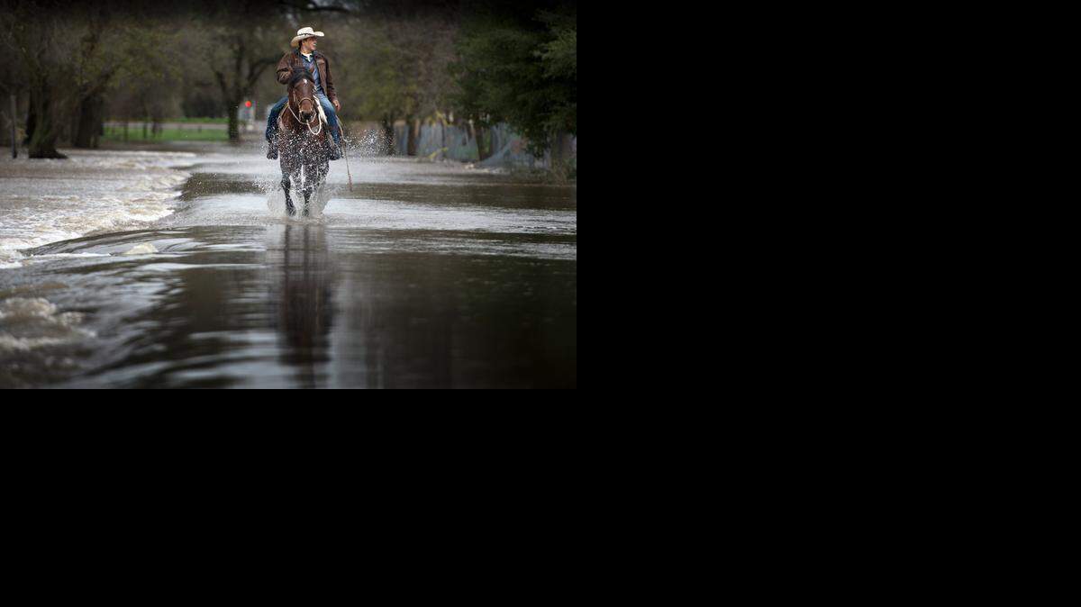 
Armando Gonzalez of Rio Linda rides his quarter horse Gitano on a flooded bike trail near Roy E. Hayer Park in Rio Linda on Friday. “I’ve seen it worse than this. It looked like a lake and you couldn’t see the grass,” Gonzalez said in Spanish.
