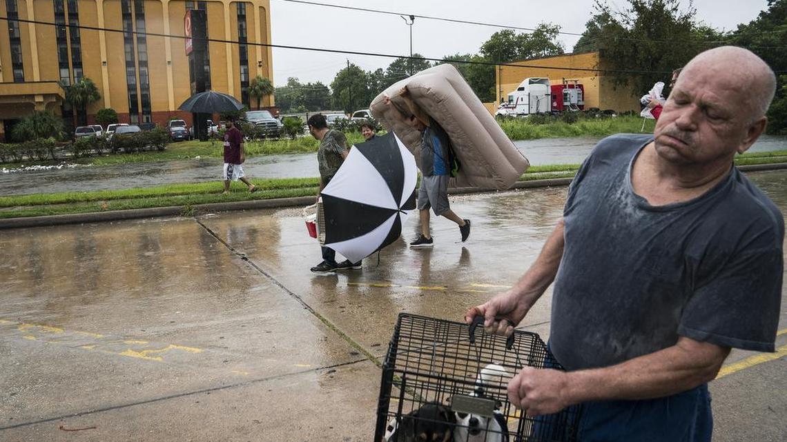 Residents carry their pets and belongings as they flee floodwater in Houston, Texas on Aug. 27, 2017.