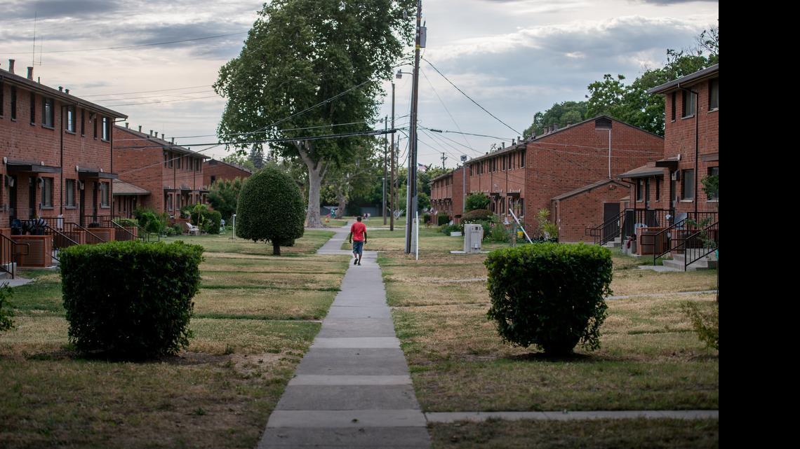 
A man walks at the Alder Grove housing project, where some residents have mixed feelings about a mixed-use neighborhood plan for the site.
