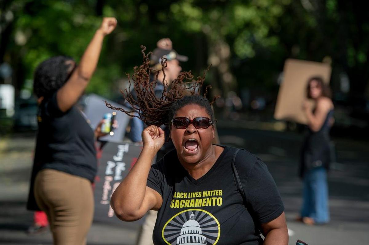 Onethia Riley of Black Lives Matters leads a small crowd of protesters in a chant of “Say his name” in front of the Sacramento DA’s office on Tuesday after the Sacramento police released the county’s autopsy report on the shooting of Stephon Clark.