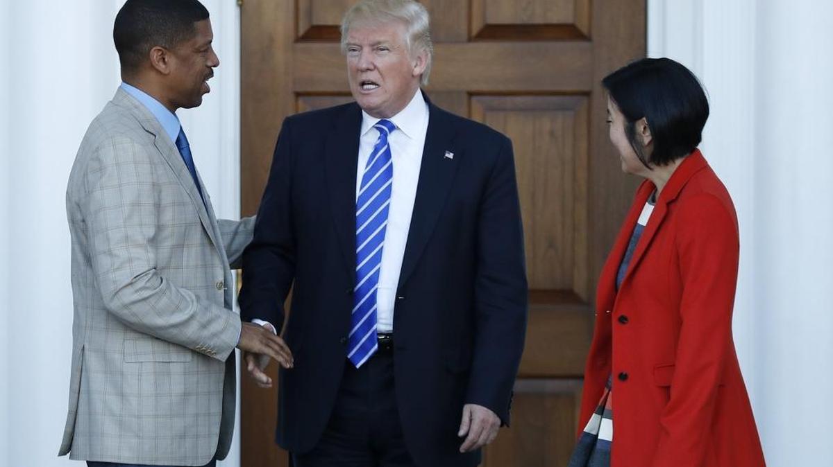 President-elect Donald Trump shakes hands with Sacramento Mayor Kevin Johnson as his wife, Michelle Rhee, a former chancellor of Washington, D.C., schools, stands at right, as they leave Trump National Golf Club Bedminster clubhouse in Bedminster, N.J., Saturday, Nov. 19, 2016.