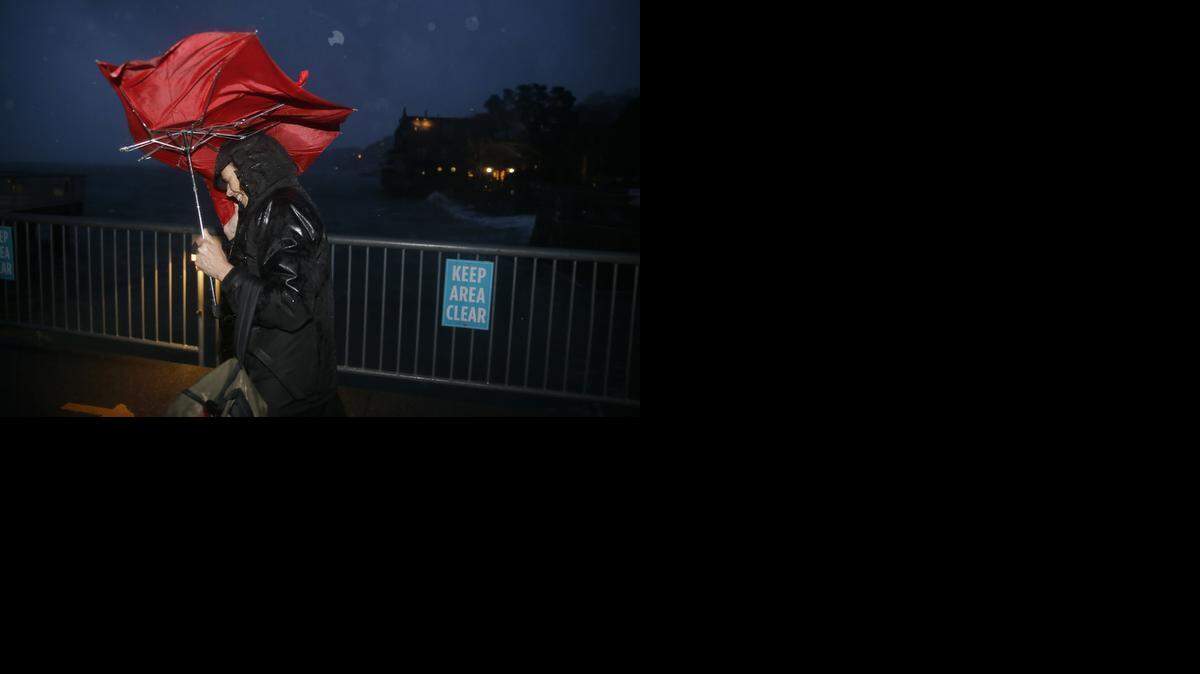
Commuter ML Mann struggles in the wind and rain to make her way to catch a ferry, Thursday, Dec. 11, 2014, to San Francisco from Sausalito, Calif. 
