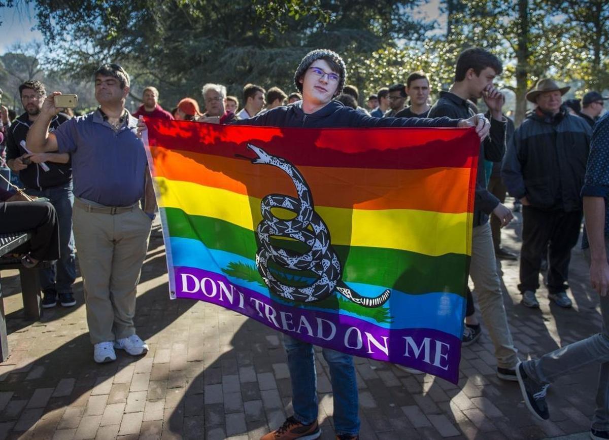 Nicholas Francois, a Log Cabin Republican and UC Davis student, holds a Gadsden flag combined with the gay pride flag in 2017. The conservative LGBTQ organization supported a push to revise the GOP’s platform positions on same-sex marriage and abortion.