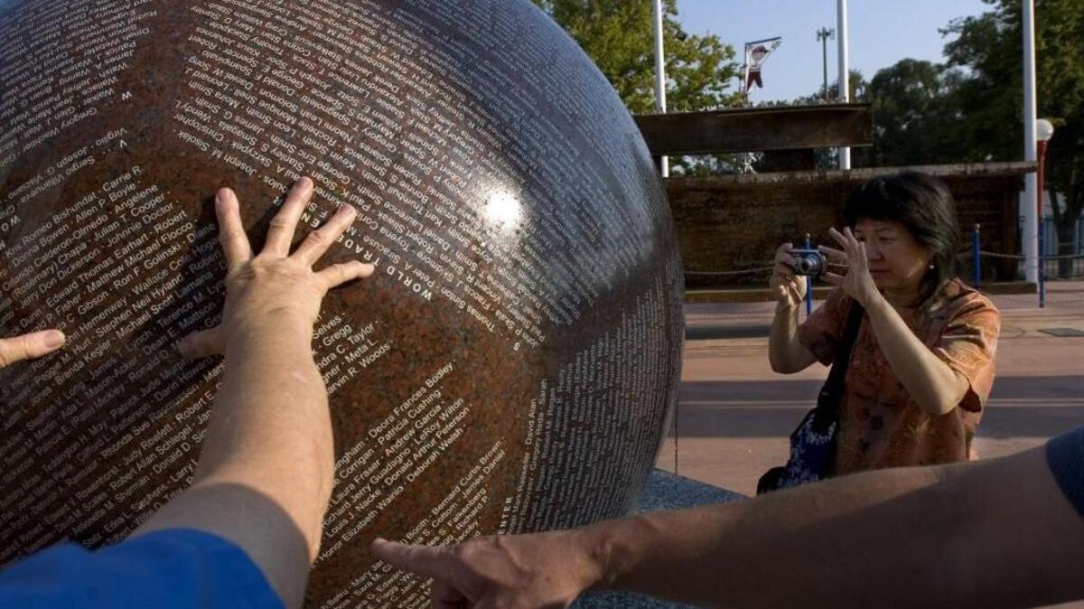 
Elizabeth Wong, of Sacramento, photographs the sphere with the names of the people who died in the 9/11 attacks.
