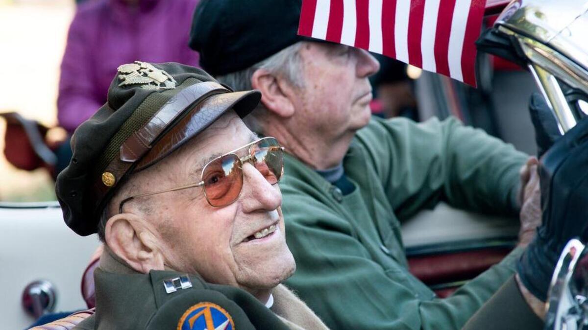 Robert Boemer, a World War II veteran, rides in a classic car during Wednesday’s Veterans Day parade.