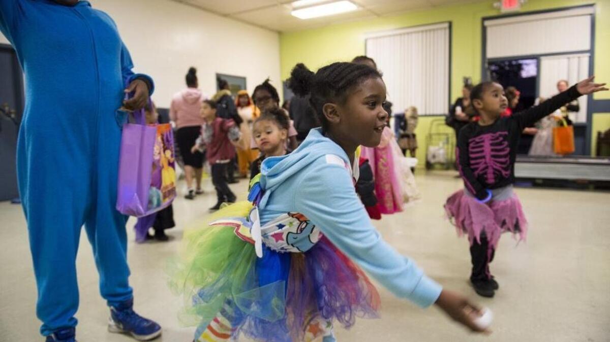 Debria Williams, 7, plays a ping-pong toss game at the community center for a Halloween trick-or-treat event hosted by the resident council of the Alder Grove housing complex. The council is trying to keep the kids from leaving the complex to go trick-or-treating in Land Park or Curtis Park.