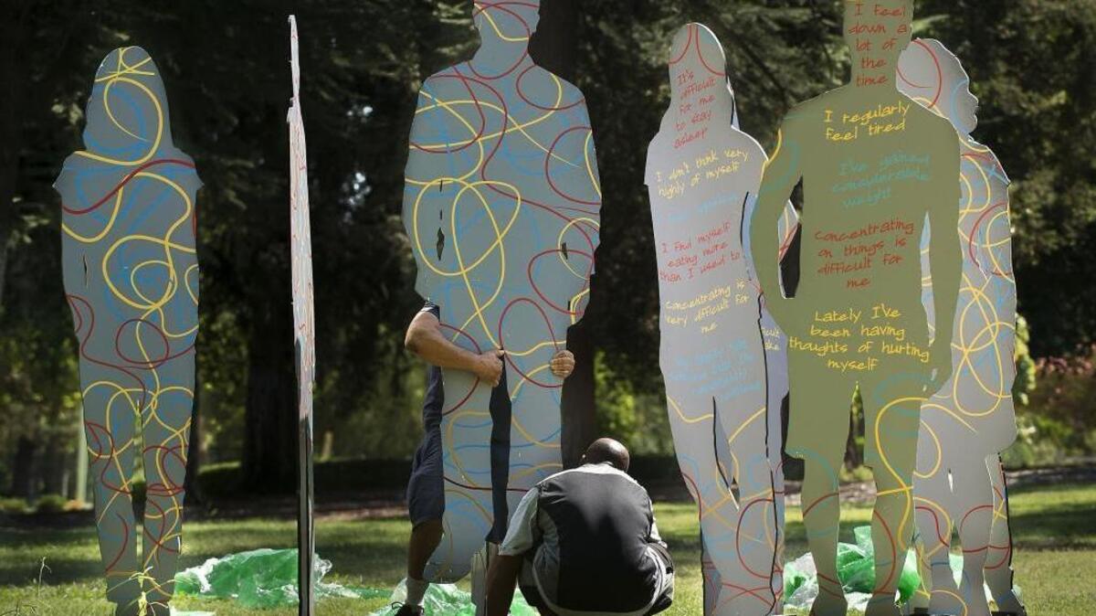 Worker Omar Anthony assembles a display of silhouettes in William Land Park in Sacramento on Friday, Aug. 26, 2016.