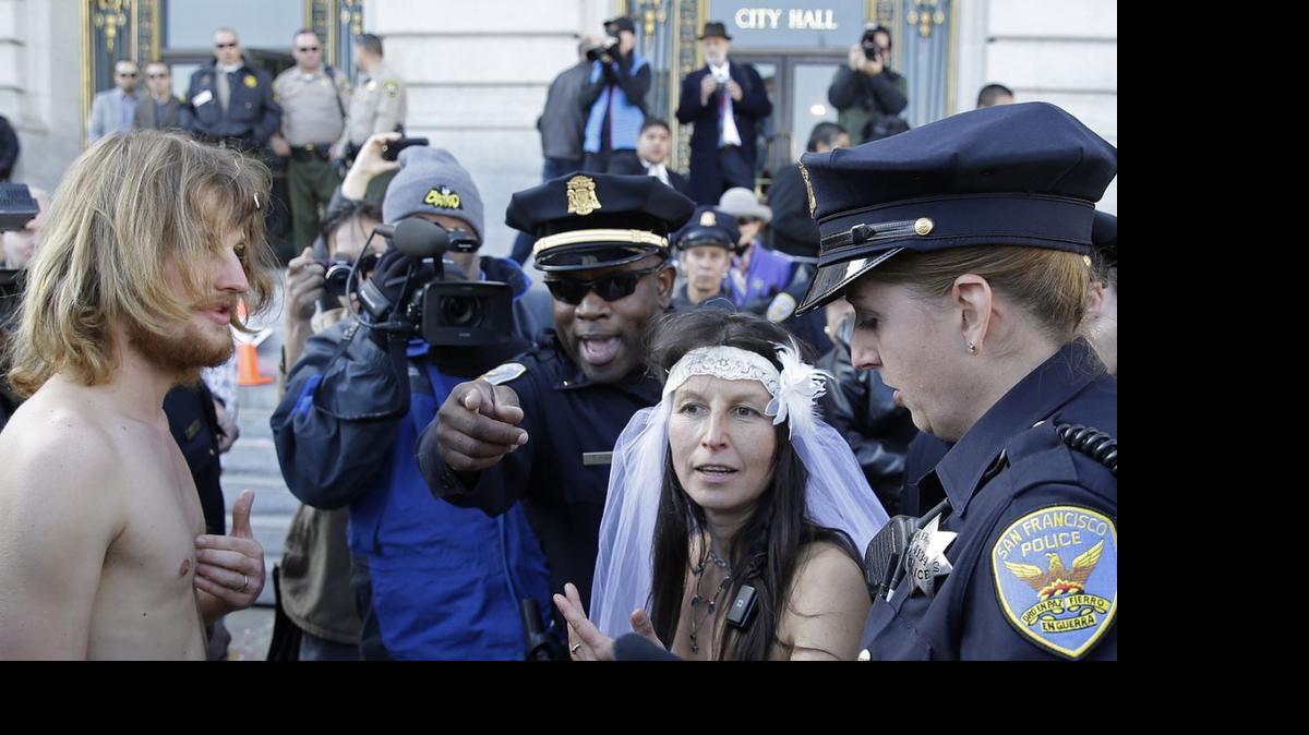 
San Francisco police lead Gypsy Taub, right, and Jaymz Smith, left, to a van after their nude wedding outside City Hall in December, 2013. In Sacramento, a proposed amended ordinance would make it illegal to be nude on city streets, sidewalks or on private property visible from a public right-of-way.
