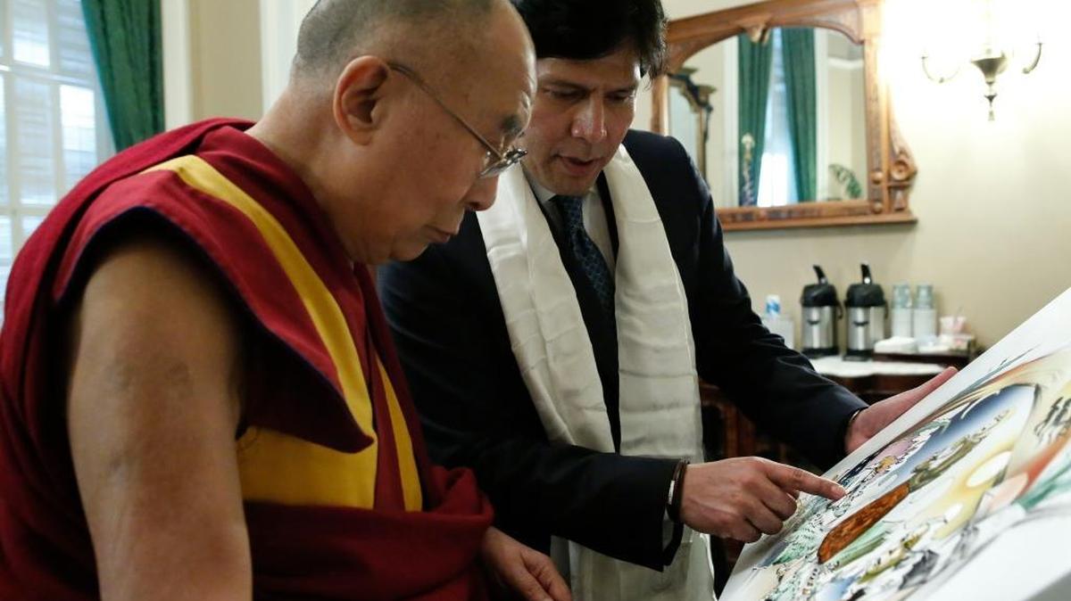 Senate President Pro Tem Kevin De León explains the details of the images to the Dalai Lama.