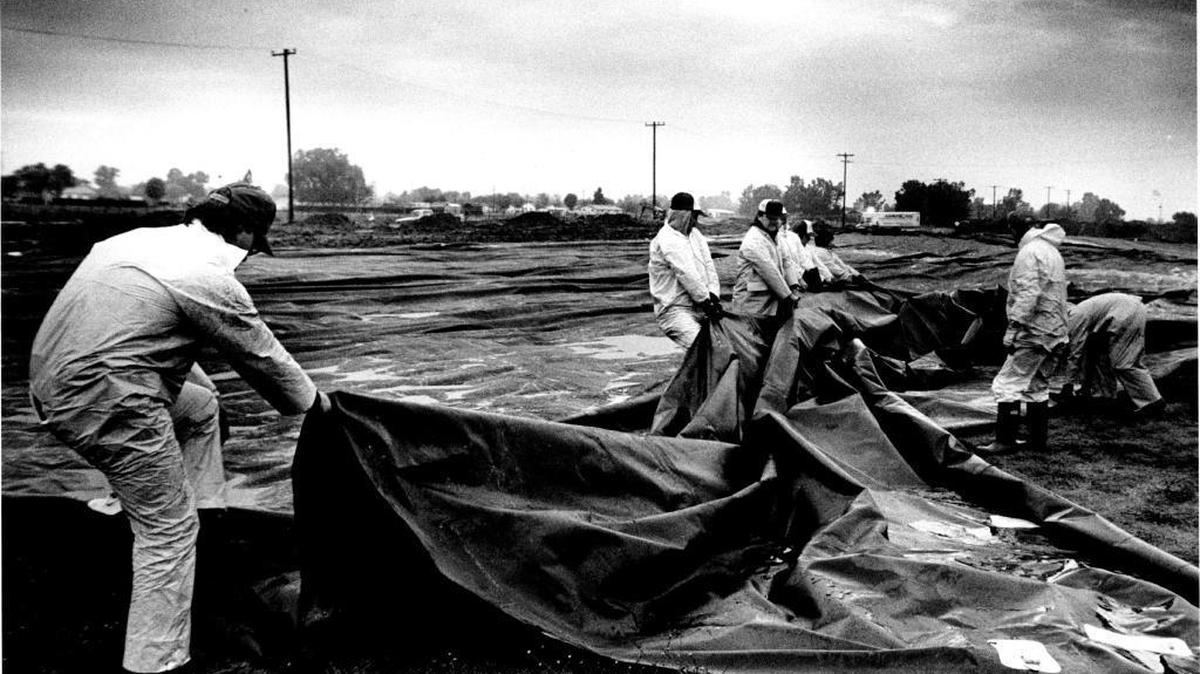 In this file photo, workers cover an acid pit at McClellan Air Force Base with tarps to try to prevent winter rains from adding to the base’s pollution problems.