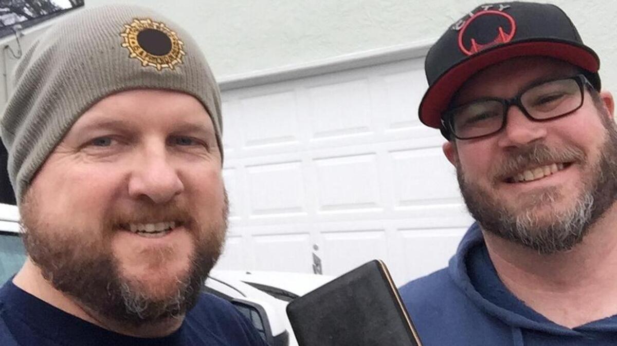 Chris Clark, left, and Chris Wunderlich pose for a picture after Wunderlich returned $4,500 found in a bumper pool table purchased online from Clark.