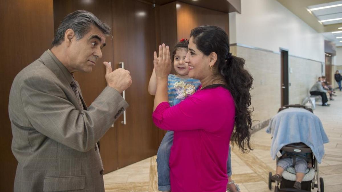 Afghan refugee Basira Haidari gives her daughter, Raheel, 4, a high-five outside of family court, after she found out from a court interpreter, at left, she could leave the shelter in Davis that she had been in since May 5th after her husband violated his restraining order and pushed his way into her apartment and slapped her on Wednesday, May 24, 2017 in Sacramento, Calif. CPS had taken away her children including son Subhan Haidari, at right, in stroller but she attended court mandated classes and has regained her children and is contributing back to the refugee community by helping others understand the resettlement process.