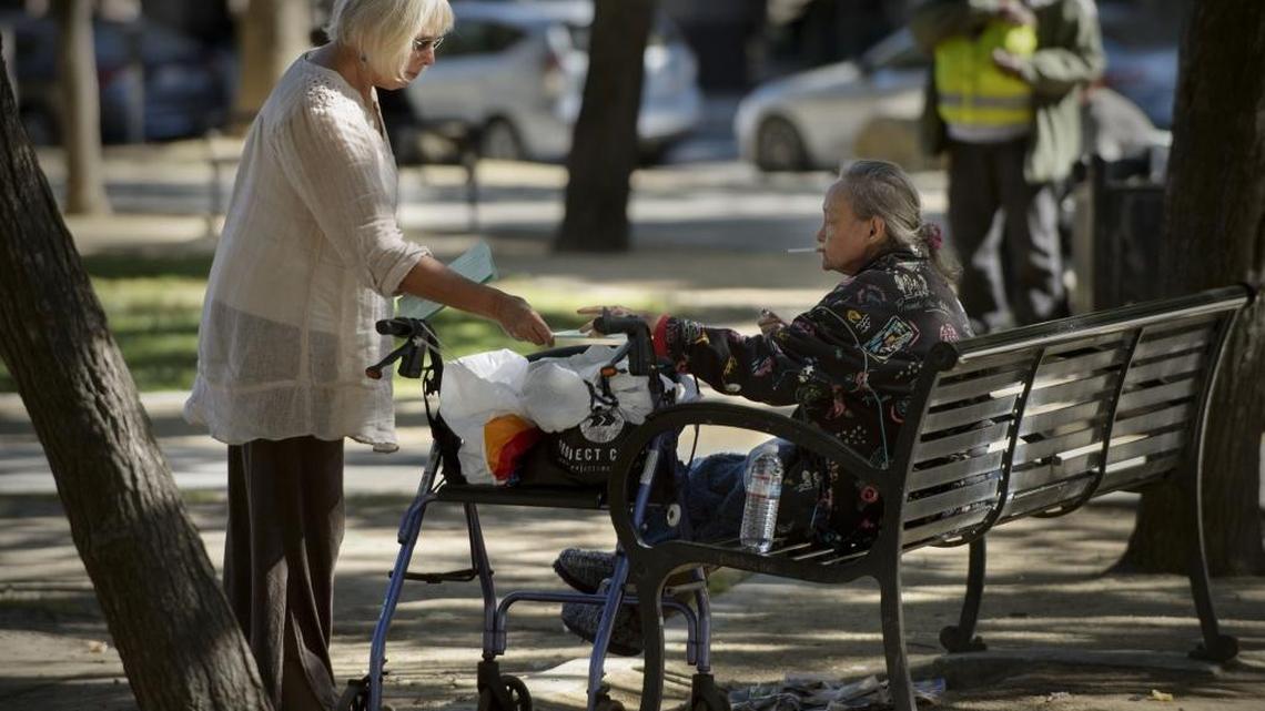 Doralee Grindler Katonah, left, offers a little kindness to a homeless woman in Cesar Chavez Park in Sacramento on Sept. 26, 2017.