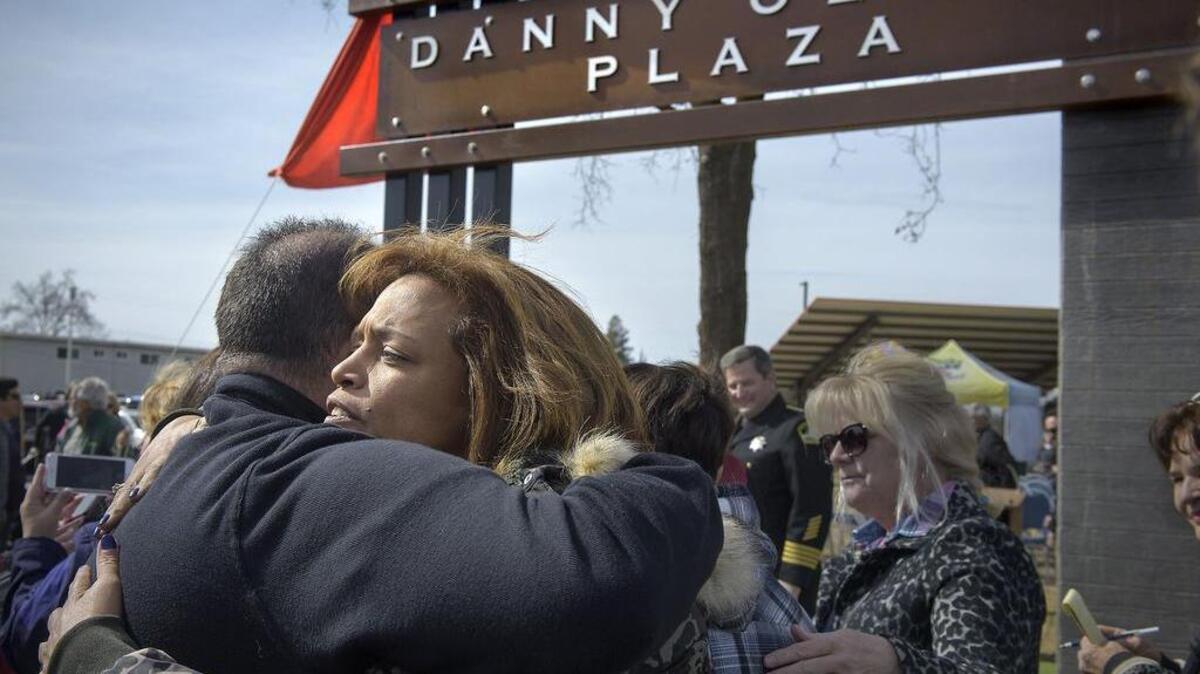 Susan Oliver, wife of slain Deputy Danny Oliver, hugs Michael Alcalay during a ceremony dedicating a new park plaza honoring Oliver. Alcalay was on the board that helped create the plaza at Eastern Oak Park in Carmichael.