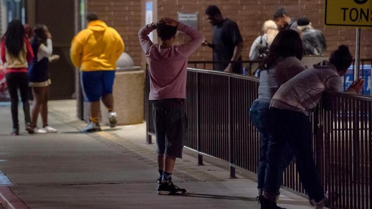 People from Grant High School wait outside the emergency entrance of Kaiser Permanente Medical Center in Sacramento on Friday, Nov. 13, 2015, to hear news about one of the two football players who were shot in a car off-campus earlier in the evening while getting food. Senior Jaulon Clavo, a starting cornerback, died at UC Davis Medical Center after being shot in the neck.