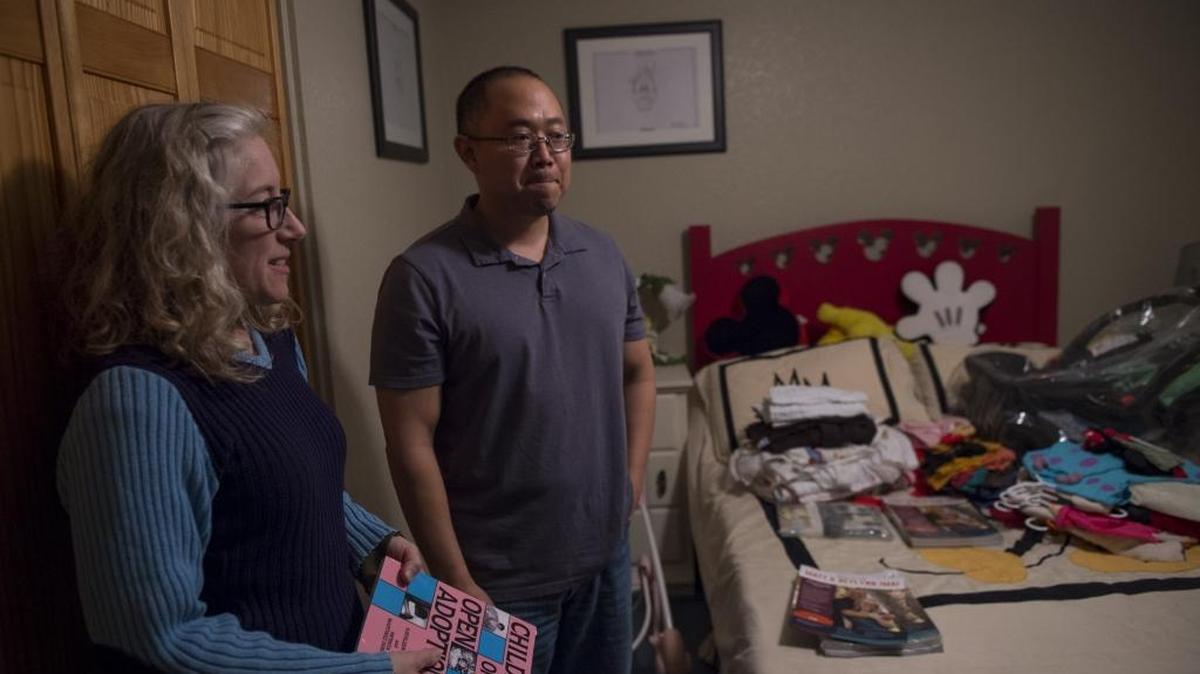 Reylynn and Matt Imai look Thursday at the room full of baby clothing and items for the child they hoped to adopt. The couple, who are unable to biologically reproduce, waited a year and a half to adopt a child through Independent Adoption Center. They may have to give up on adoption after a Concord agency unexpectedly shut down due to bankruptcy.