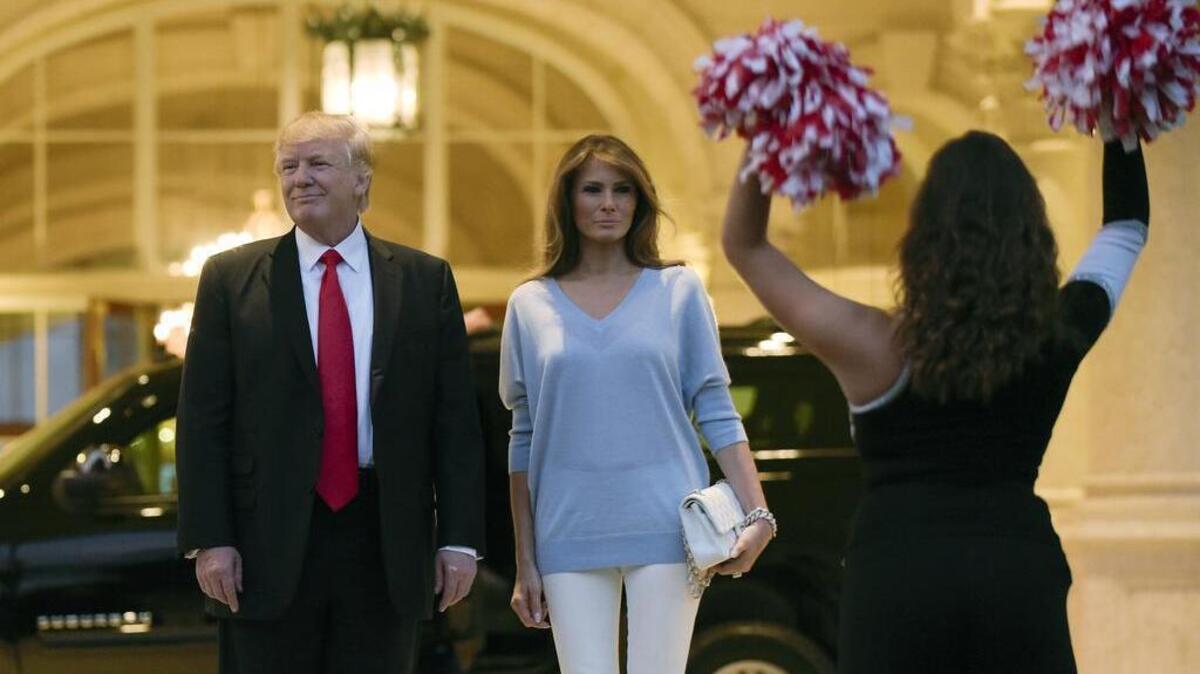 President Donald Trump and first lady Melania Trump watch the Palm Beach Central High School Band as they play for their arrival at Trump International Golf Club in West Palm Beach, Fla., Sunday, Feb. 5, 2017. The Trumps are attending a Super Bowl party at the club.