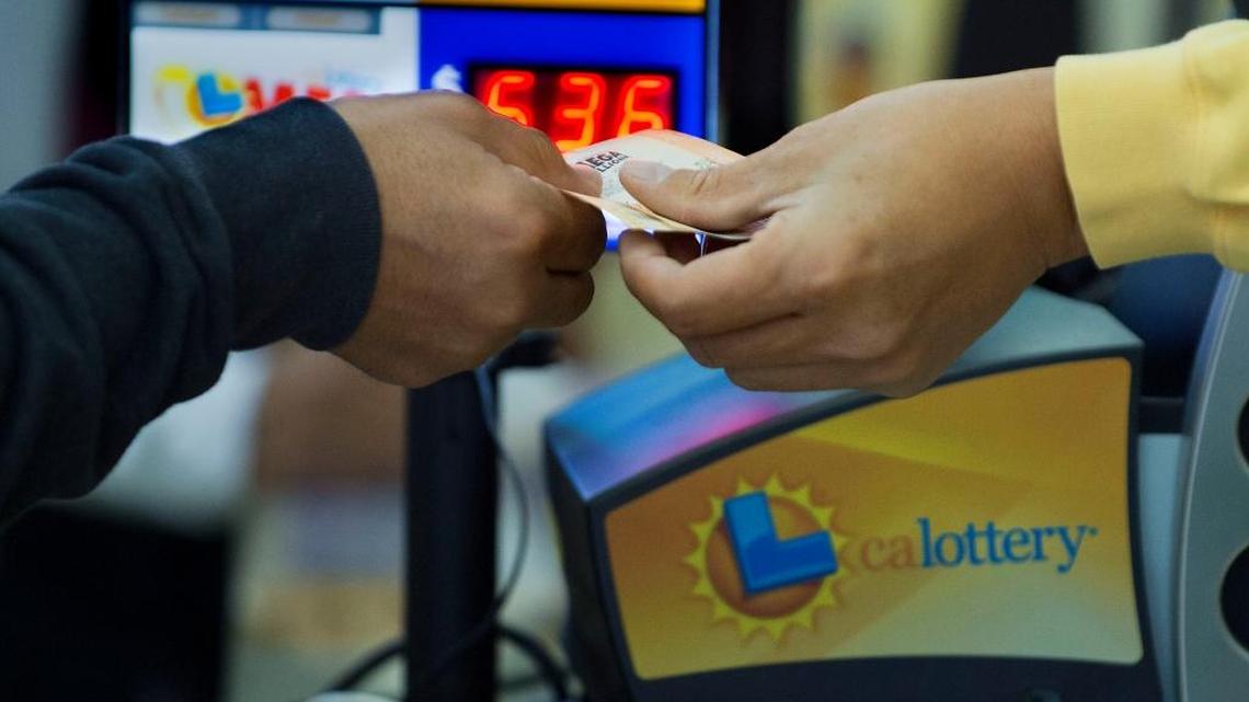 FILE -- A customer buys a Mega Millions lottery ticket in the Land Park area on in December 2013.