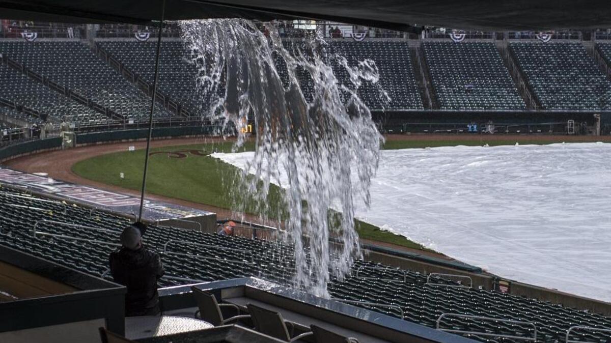 An employee of Raley Field releases water from sun shades during the RiverCats opening day before it was rained out at Raley Field on Thursday. The River Cats face the Tacoma Rainiers tonight.