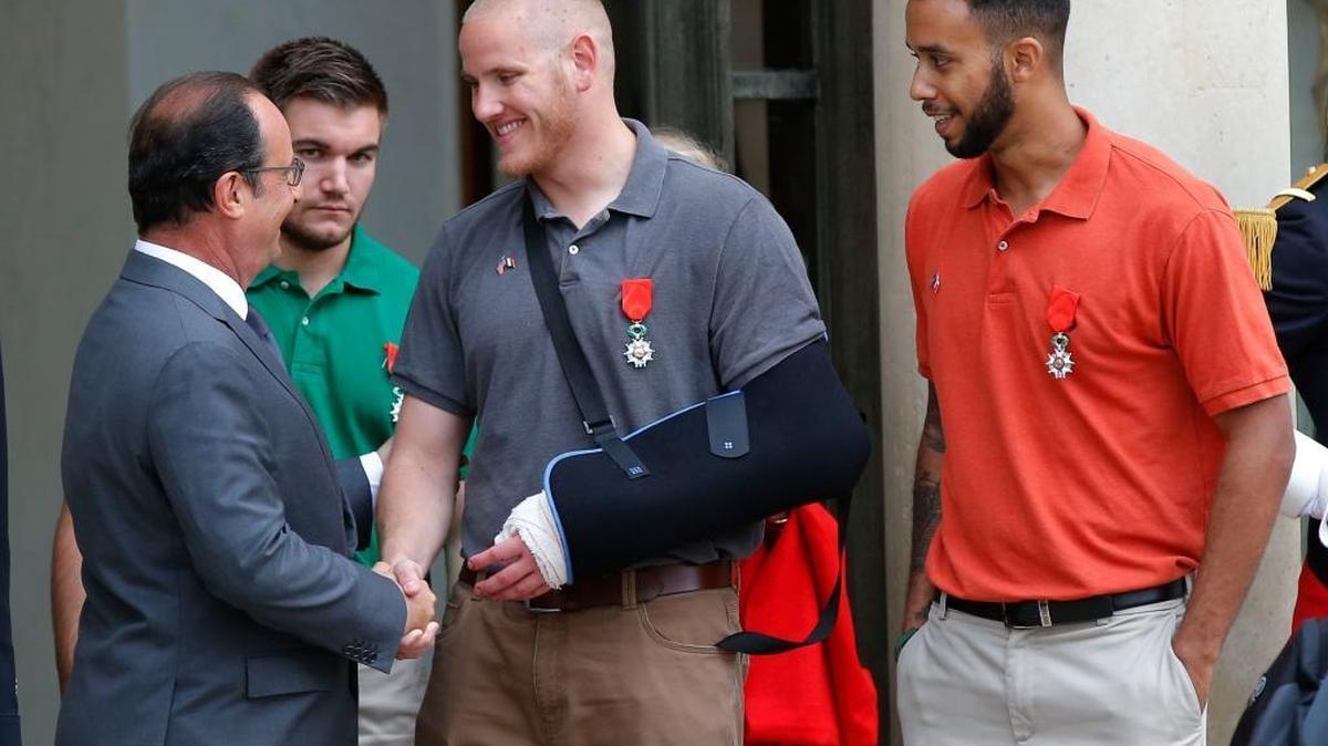 
French President Francois Hollande, left, shakes hands Aug. 24 with U.S. Airman Spencer Stone as U.S. National Guardsman Alek Skarlatos, second from left, and Anthony Sadler, a senior at Sacramento State, right, look on. 
