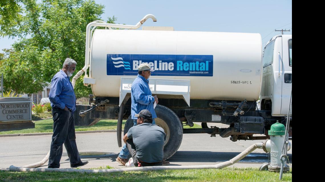 
Mohamad Abdul, left, owner of M&M Mobile Truck Repair, talks to men that he hired to help fill pot holes and level the land at his new location on Elder Creek Road in Sacramento. Abdul said he didn't know the contractor he hired was operating without a meter or permit to take water from city hydrants.
