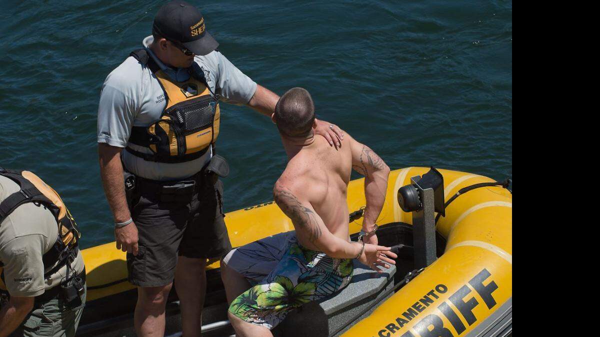 Sacramento Sheriff's deputies arrest a rafter along the American River in Rancho Cordova on Saturday, July 13, 2013, during the Rafting Gone Wild event.