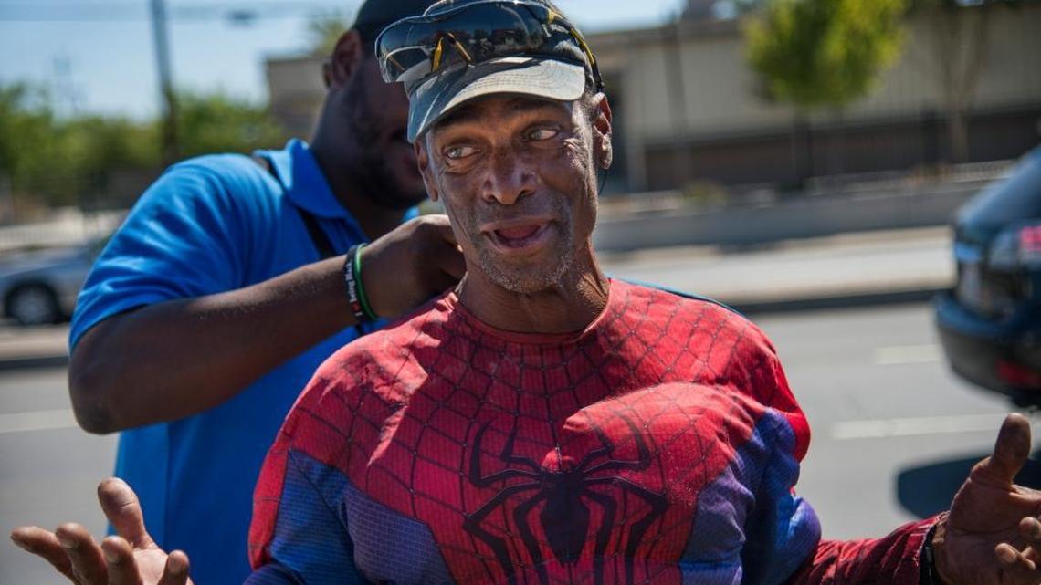 Known as “Dancing Dan” to many commuters in the Arden Arcade area, Daniel Sloan, 62, gets help zipping up his Spider Man costume, from Omega Ramos, a homeless outreach navigator with Sacramento Steps Forward on August 9, 2016. Sloan was hospitalized after being attacked Sunday night.