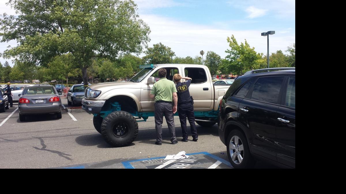 
Investigators examine the truck that was driven by a man killed in a shooting Sunday outside Home Depot on Meadowview Road in Sacramento.

