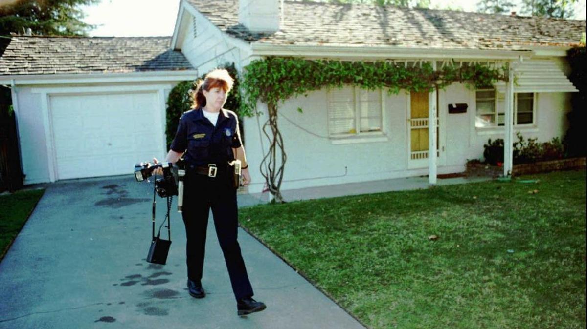 Sacramento police investigator Maria Nadeau leaves a home on Oct. 14, 1996, where authorities discovered the body of a woman who had been killed two weeks prior. Suspected in the killing is Robert Castorena, the woman’s husband.