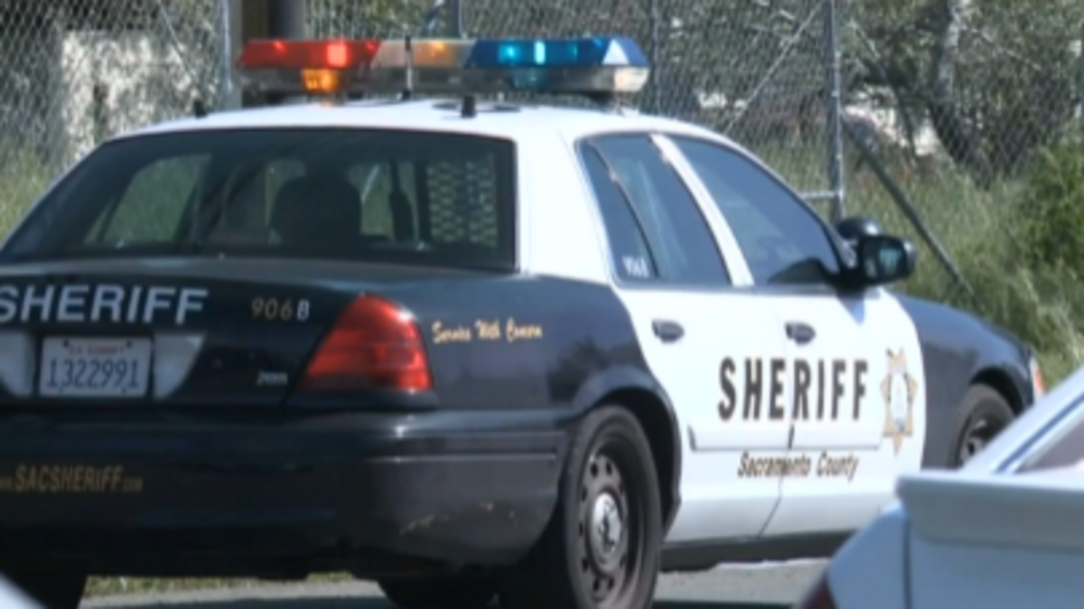 A Sheriff’s car sits outside the house in North Highlands where a man was shot in his driveway.