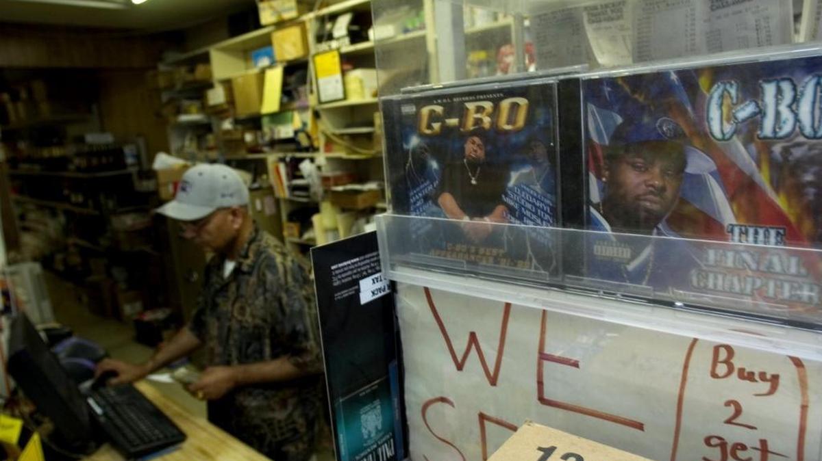 Satwant Verma rings up a sale in 2006 at the Punjab International Market in South Sacramento. At right, the music created by Sacramento hip hop artist C-BO is sold at the counter.