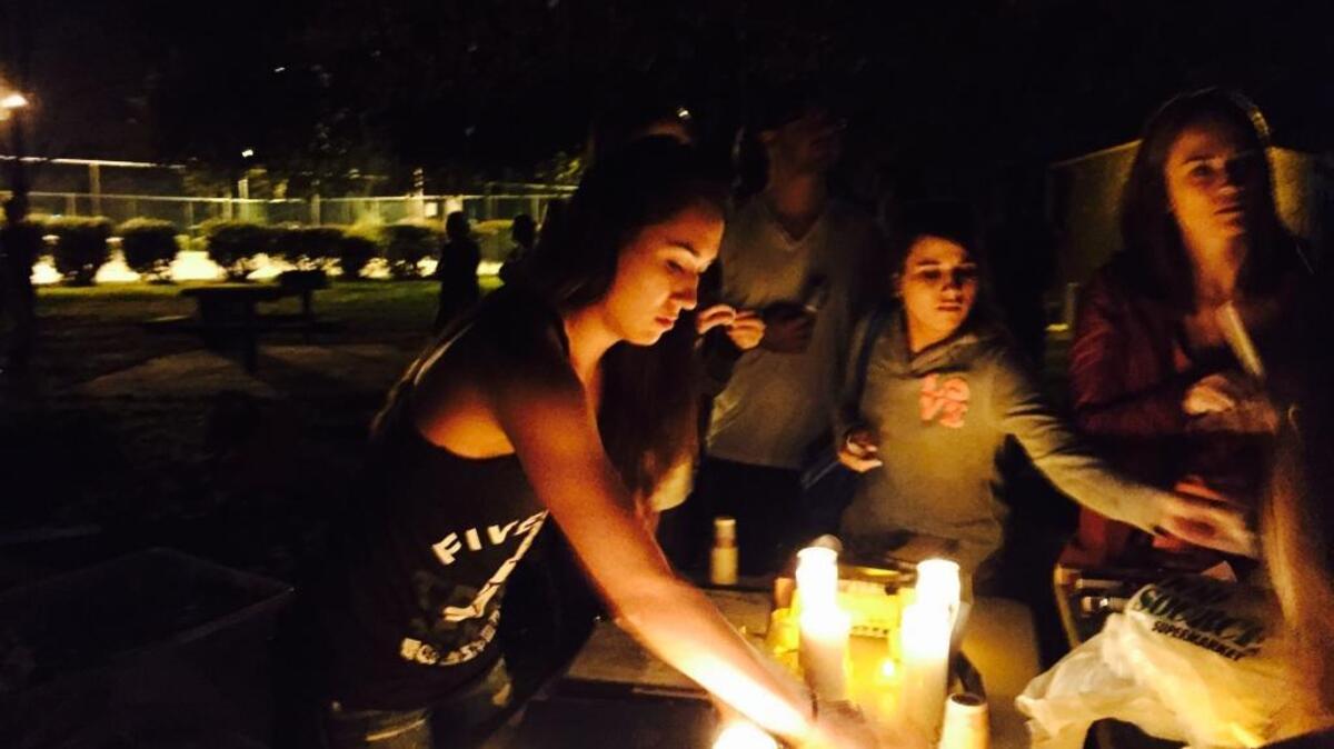 Friends light candles at a vigil in memory of Brett Jones, a corporal in the U.S. Marine Corps Reserves, who died in a crash early Thursday morning on Highway 50.