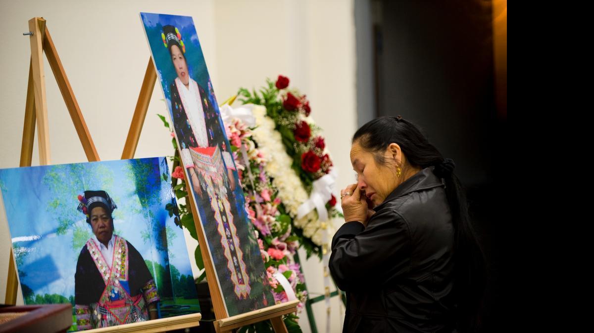 
Mai Lor Xiong wipes a tear as she looks at the photos of her aunt, Pia Xiong, who died from injuries sustained in a 2008 bus crash in Colusa.
