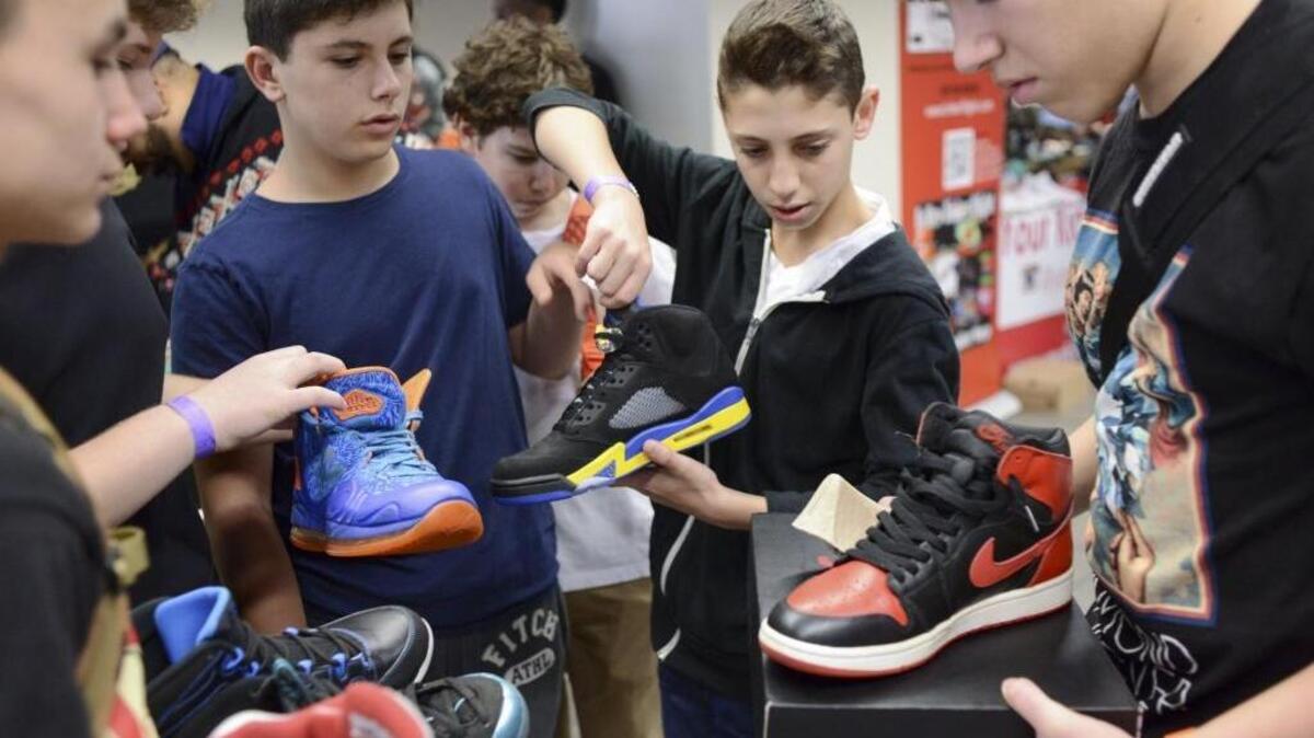Ryan Horowitz, 14, center, negotiates over a pair of Air Jordan samples that were released only in Shanghai, at the Sole Xchange fair in the Penn Plaza Pavilion in New York, March 22, 2014. Thousands of "sneakerheads," often teenagers, have formed a thriving subculture devoted to collecting and trading sneakers at events like this one.