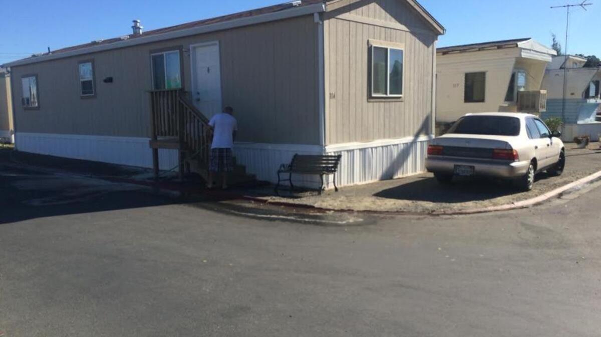 An unidentified man washes blood from the front steps of a Woodland mobile home Aug. 31, 2016, after a man was stabbed to death in the area the night before. Woodland police said they were shot at while investigating the homicide.