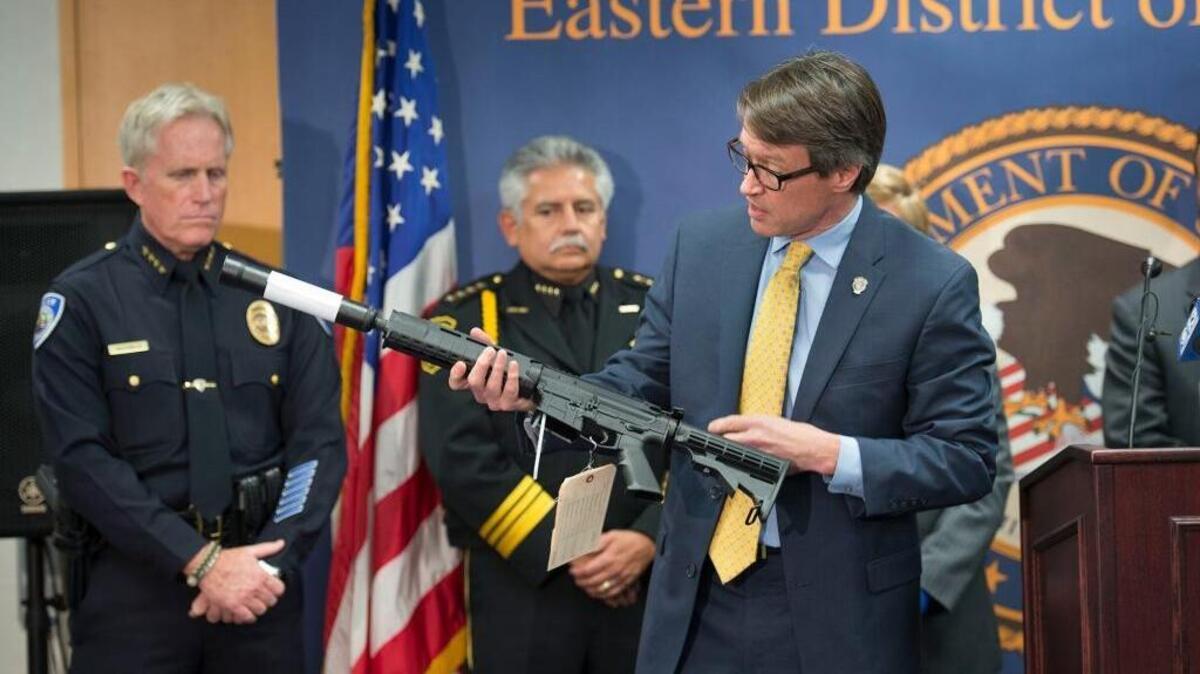 U.S. Attorney Benjamin Wagner holds an AR-15 type assault weapon during a news conference on Thursday, Oct. 15, 2015, in Sacramento. The weapons were sold to undercover agents in a sting operation that stretched from February to the end of last month. A federal grand jury in Sacramento on Thursday returned a 70-count indictment charging eight area men with manufacturing and dealing in firearms without licenses.