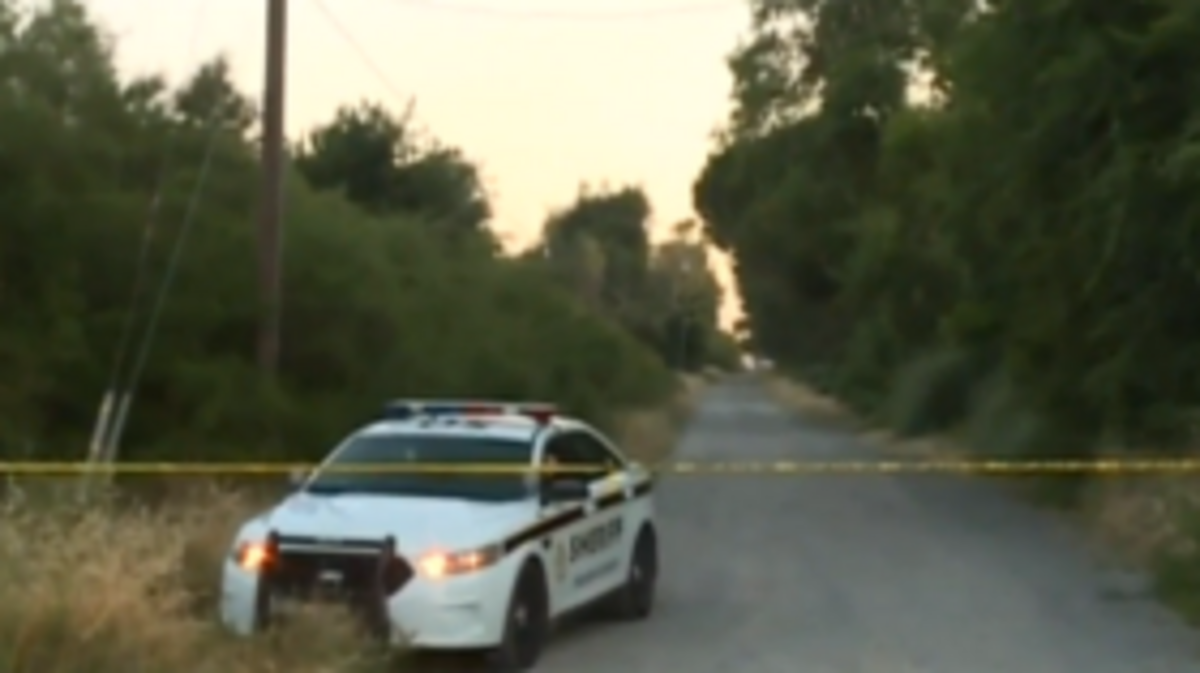 Sheriff’s deputies investigate a homicide report farther down this road.