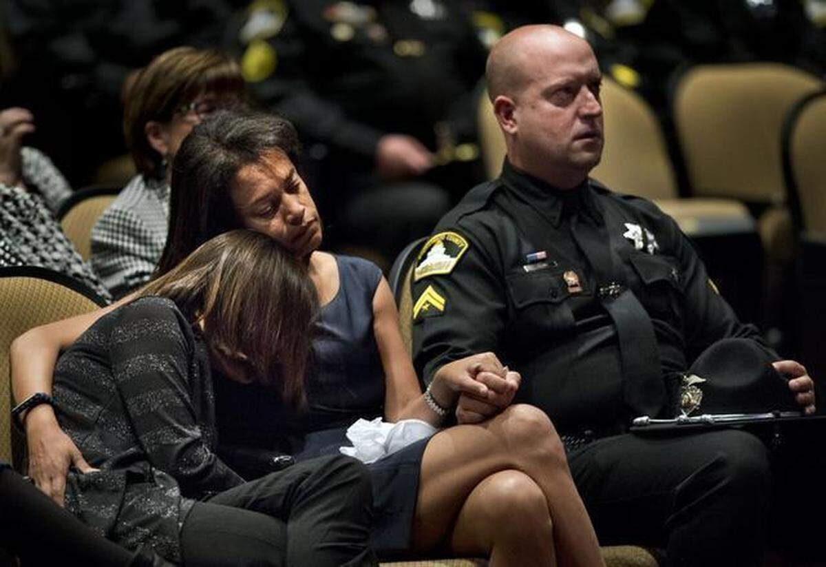 Susan Oliver, wife of Sacramento County sheriff’s Deputy Danny Oliver, embraces her daughter Jenny, and holds the hand of her husband’s partner during a memorial service Nov. 3, 2014, at Adventure Christian Church in Roseville.