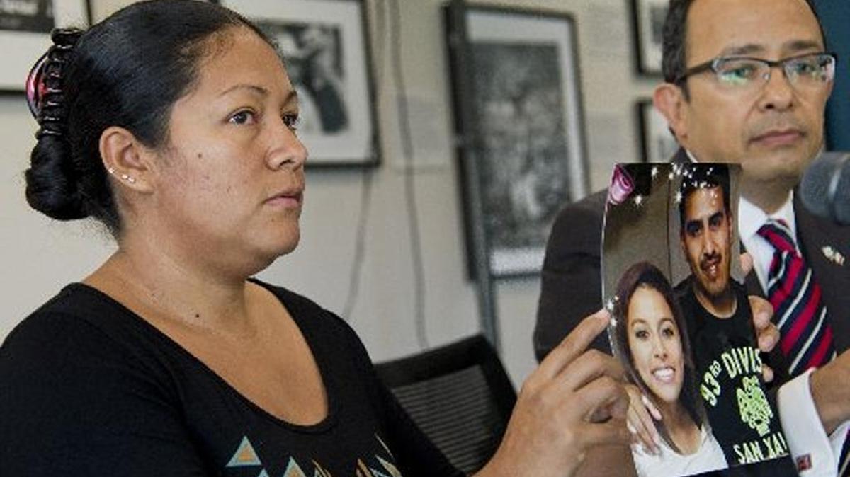 Anahi Corona-Tovar holds up a picture of her husband, Jose Luis Barriga-Tovar, 35, and 14-year-old daughter Anahi, who were killed in a car crash.