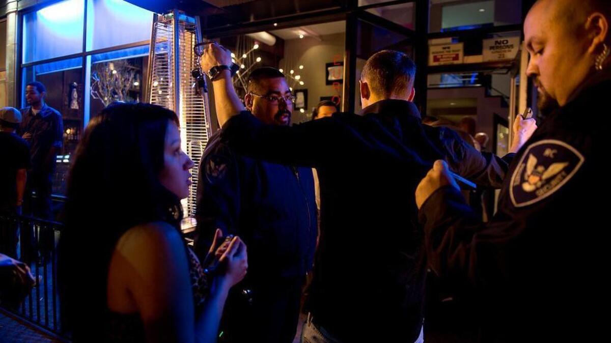 Parlare security Ricardo Cueto, center, and Giovanni Escobar, right, check IDs and use a detection wand at the entry to the Parlare Euro Lounge to keep it free of weapons on 10th Street in midtown Sacramento on March 28, 2013.