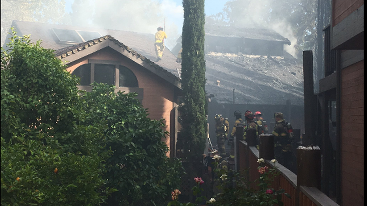 Fire crews work to extinguish a fire at a home on Lieno Lane in the Arden Arcade area.