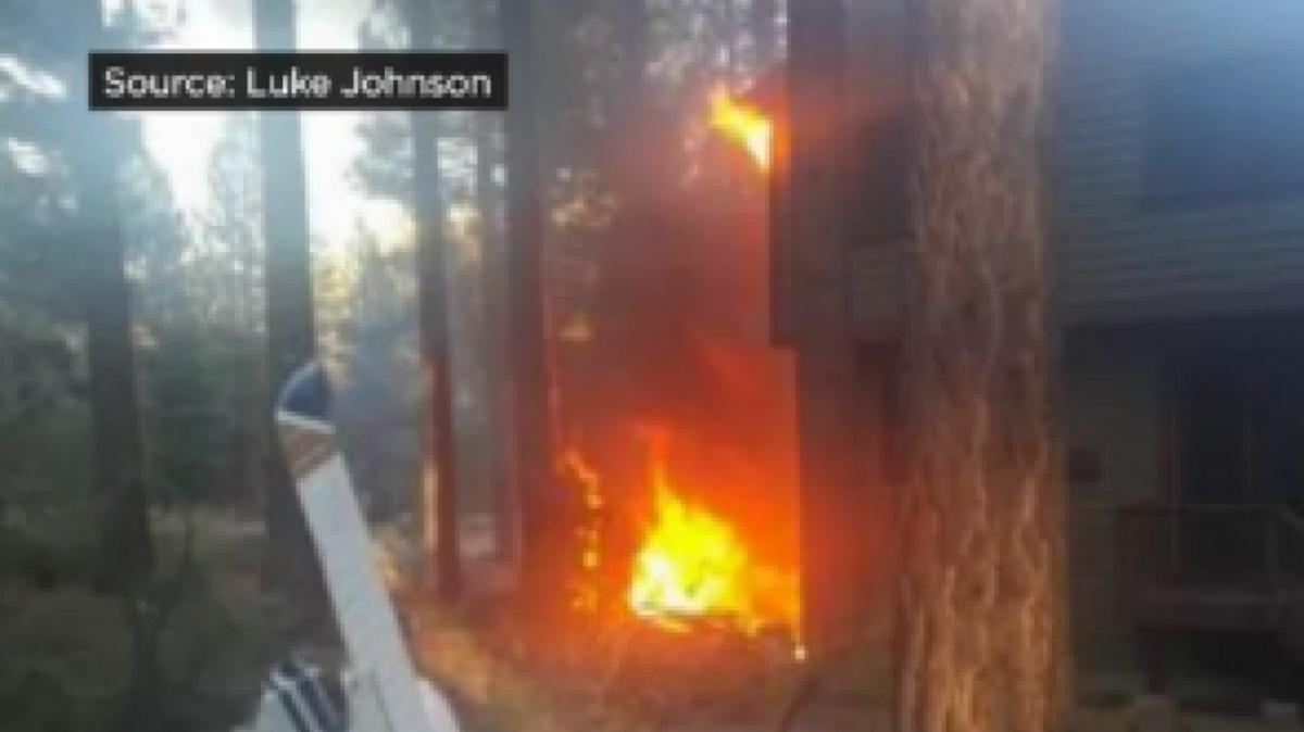 
In an image from video, fire from a fatal South Lake Tahoe plane crash spreads to a nearby residence.
